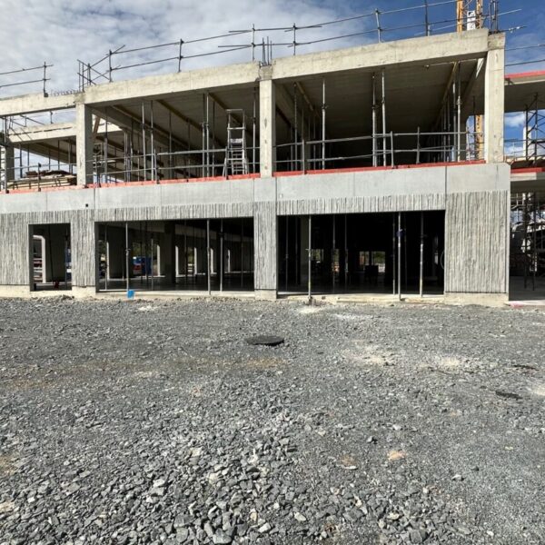 Personnes à l’intérieur du chantier de La Passerelle 2. Vue extérieure du bâtiment de La Passerelle 2 en cours de construction.