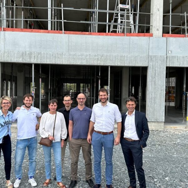 Personnes devant le bâtiment en construction de La Passerelle 2.